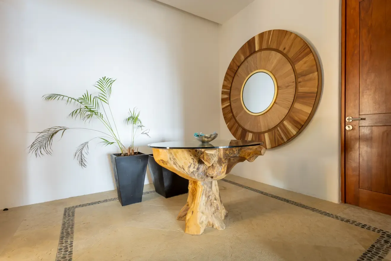 Recibidor con mesa de raíz de madera y espejo circular