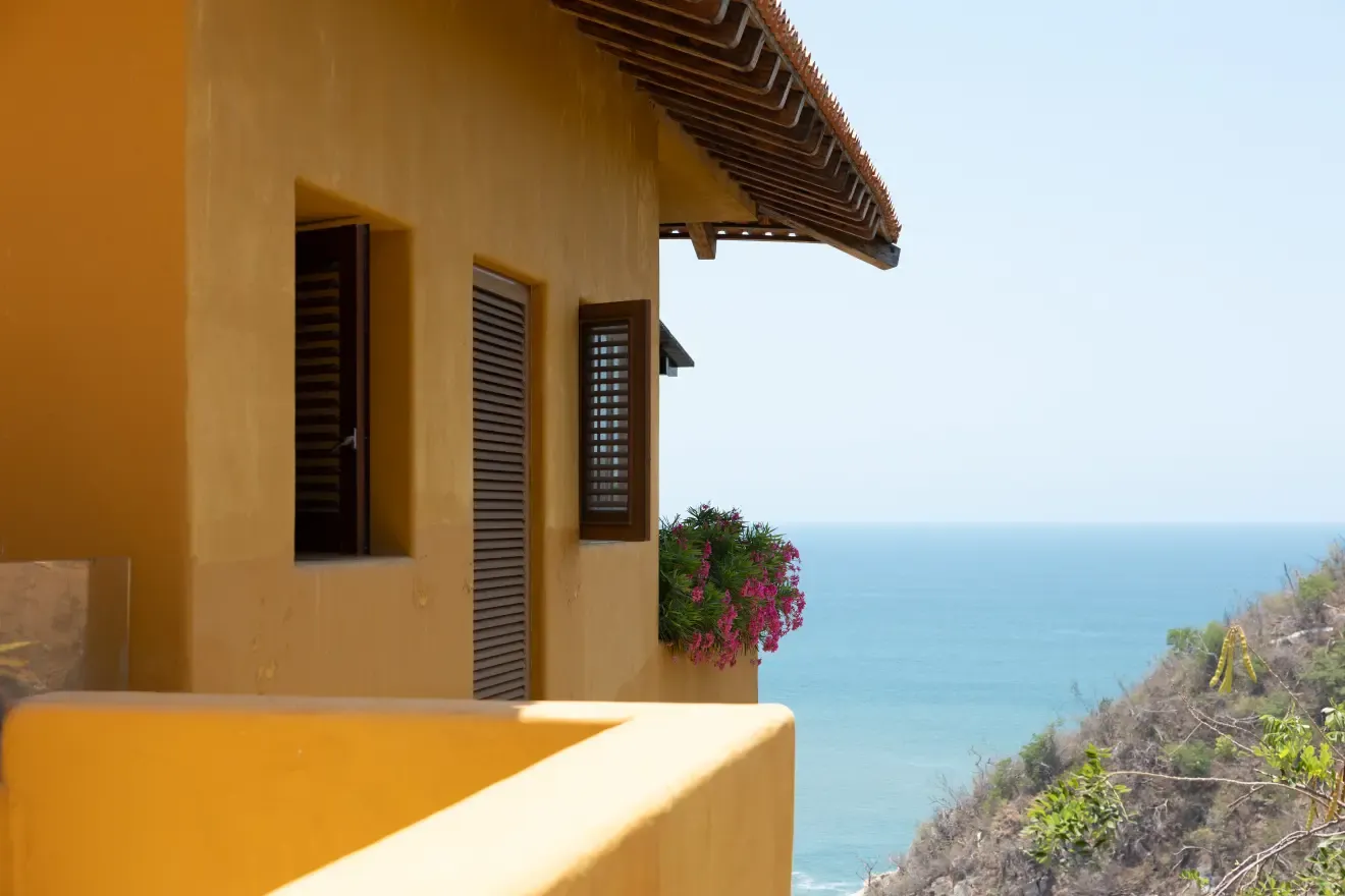 Fachada amarilla de la villa sobre el acantilado