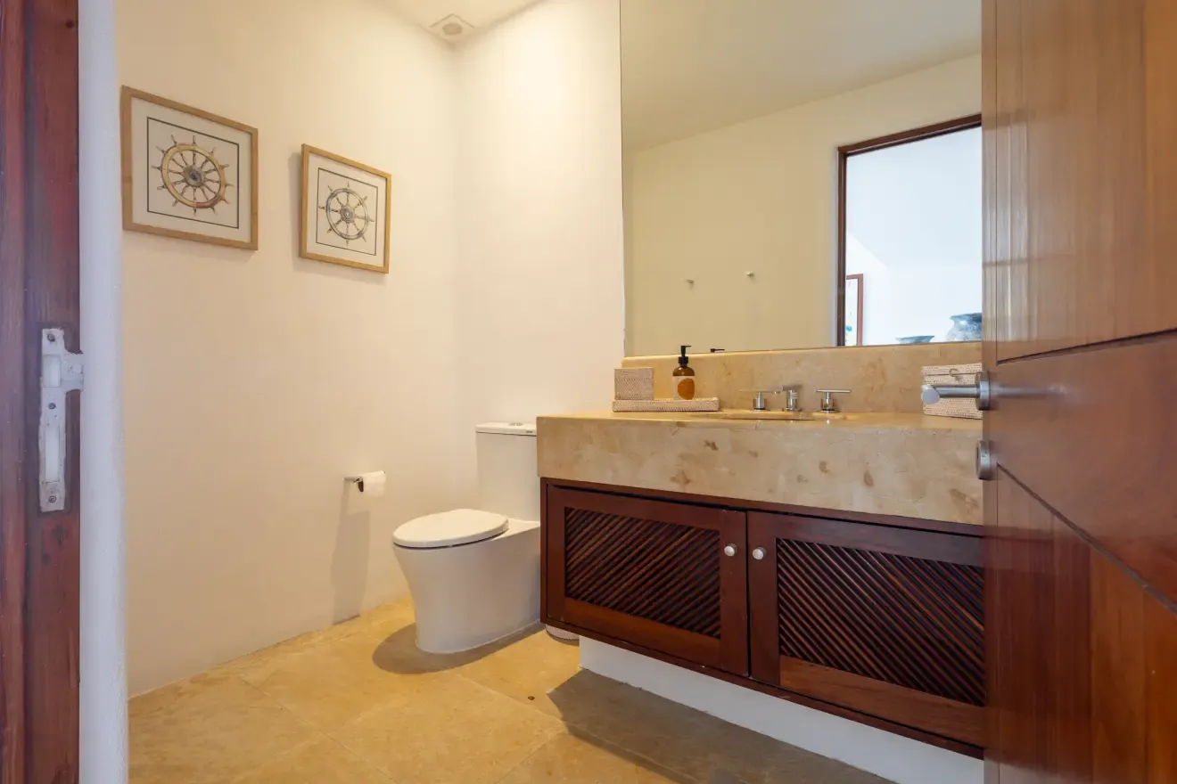 Medio baño con lavabo de mármol y espejo