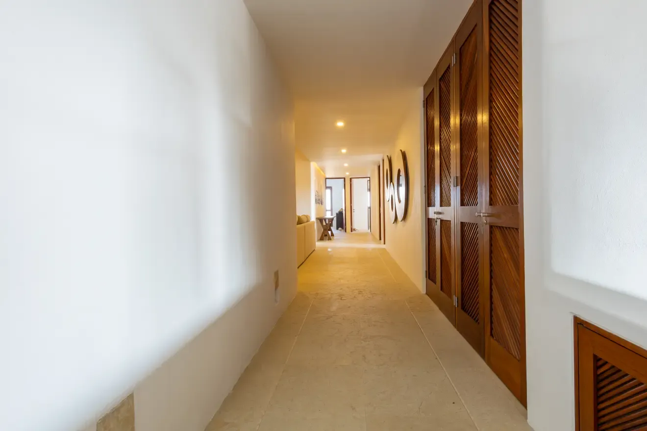 Pasillo interior con puertas de madera hacia las recámaras