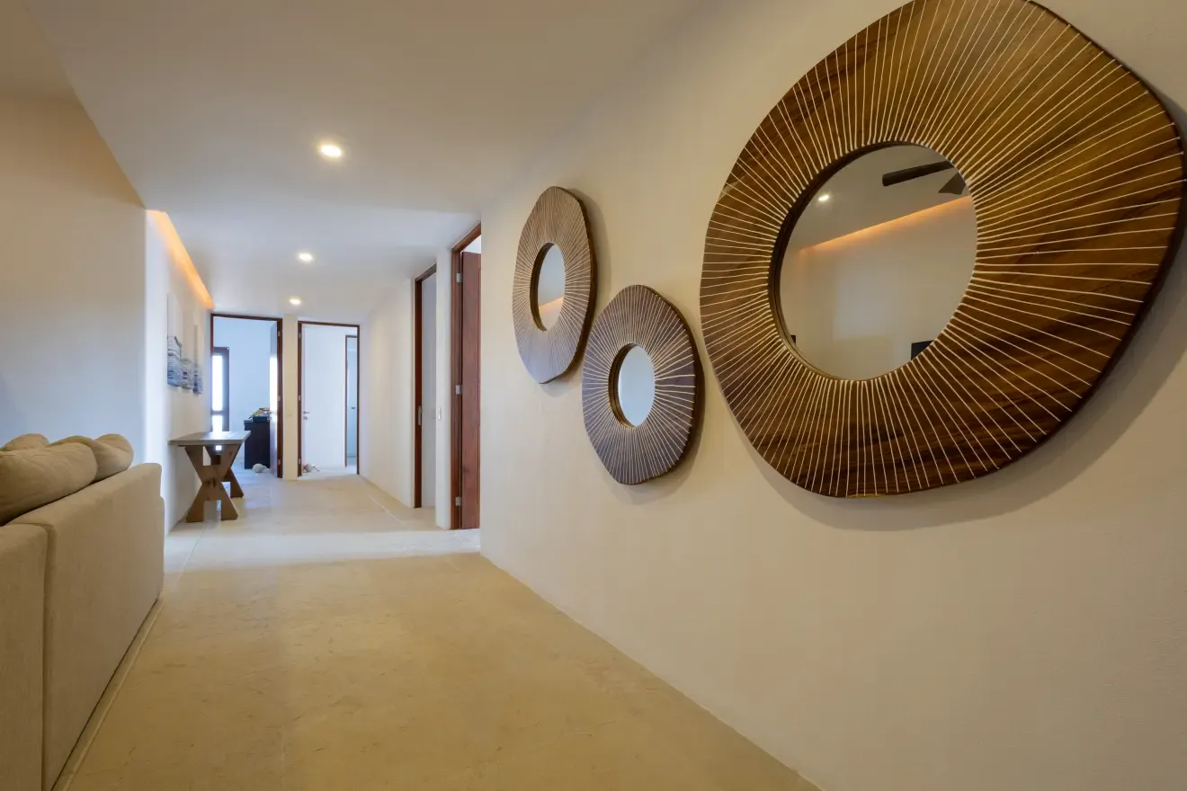 Pasillo interior con espejos circulares de madera